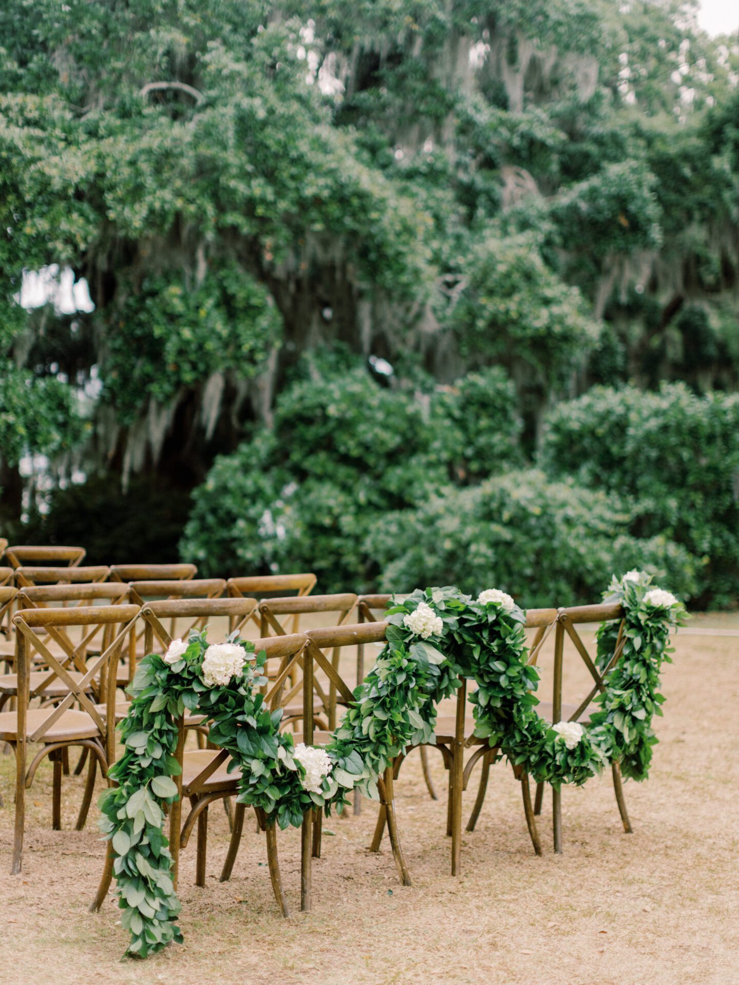 A wedding ceremony set up with chairs and greenery.