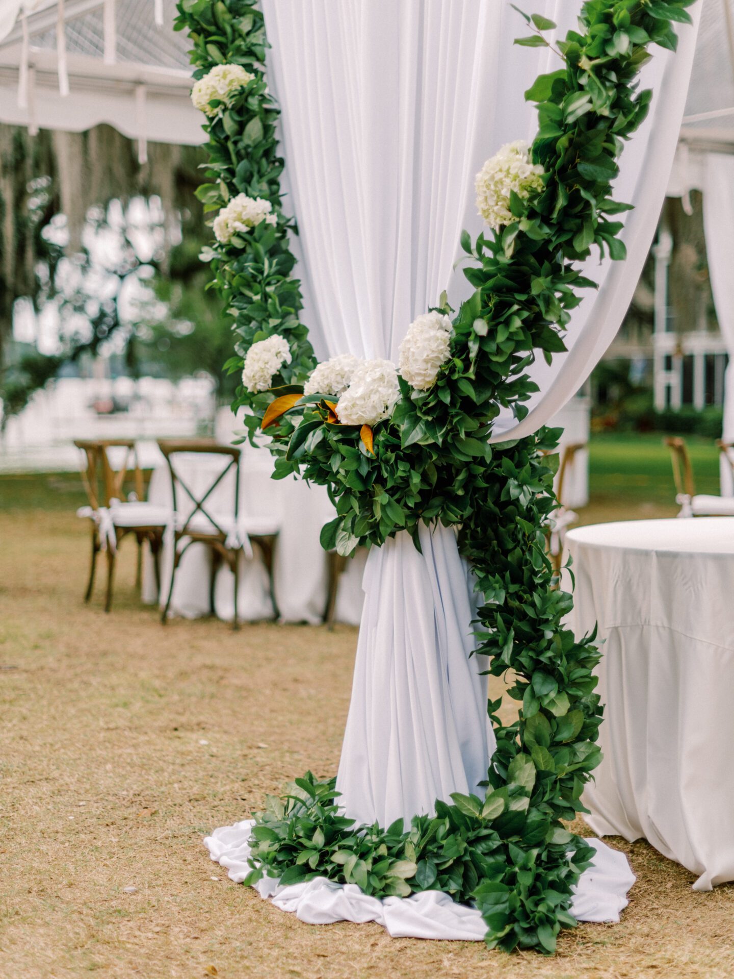 An outdoor wedding with greenery and flowers.