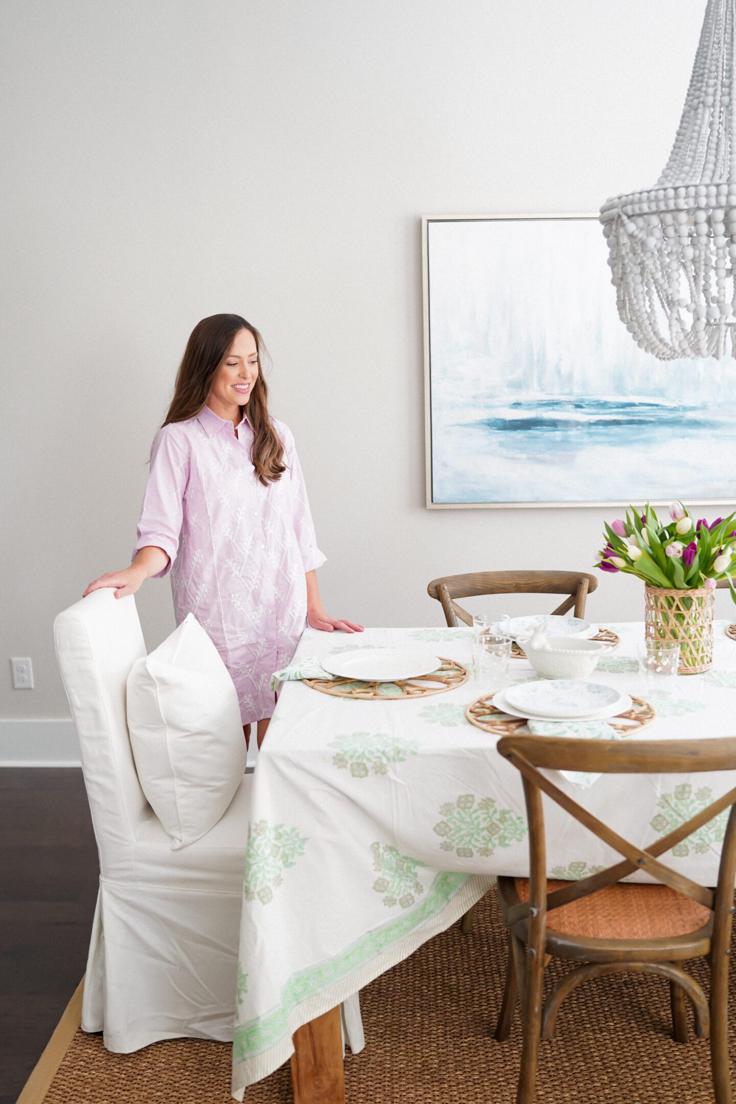 a woman standing next to a dining table